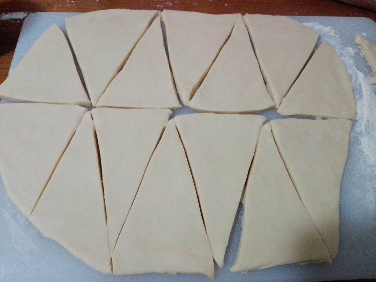 Stendere l'impasto e tagliare la pasta stesa a triangoli