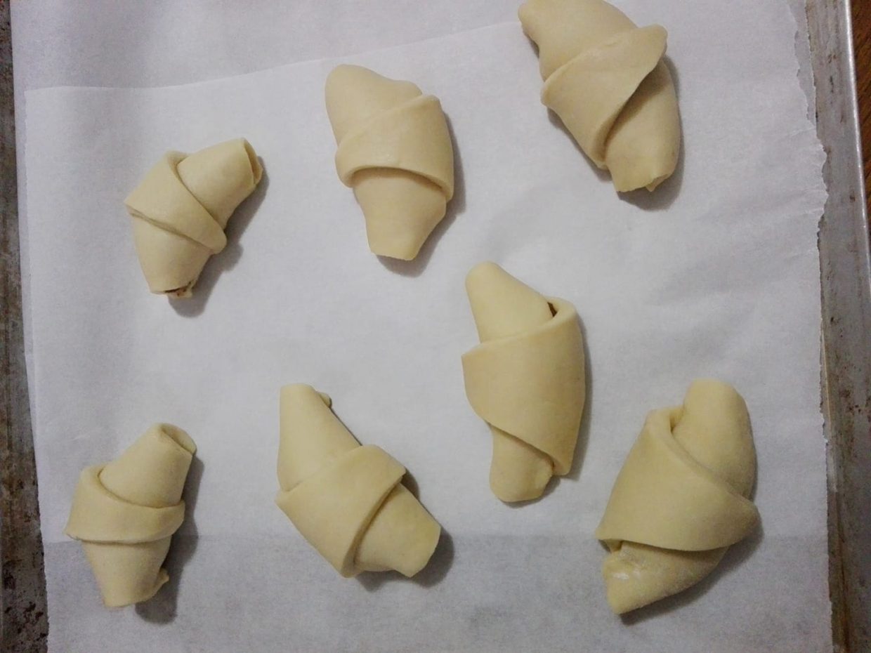 Una volta aggiunto il ripieno arrotolare i triangoli fino a creare la classica forma a cornetto. 